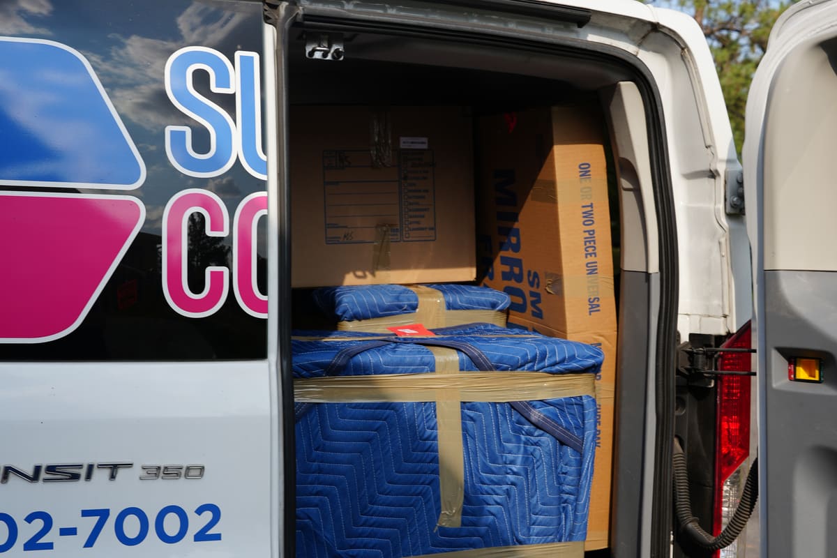 Blanket-wrapped furniture and labeled boxes loaded into a Superior Contents van during an on-site pack-out